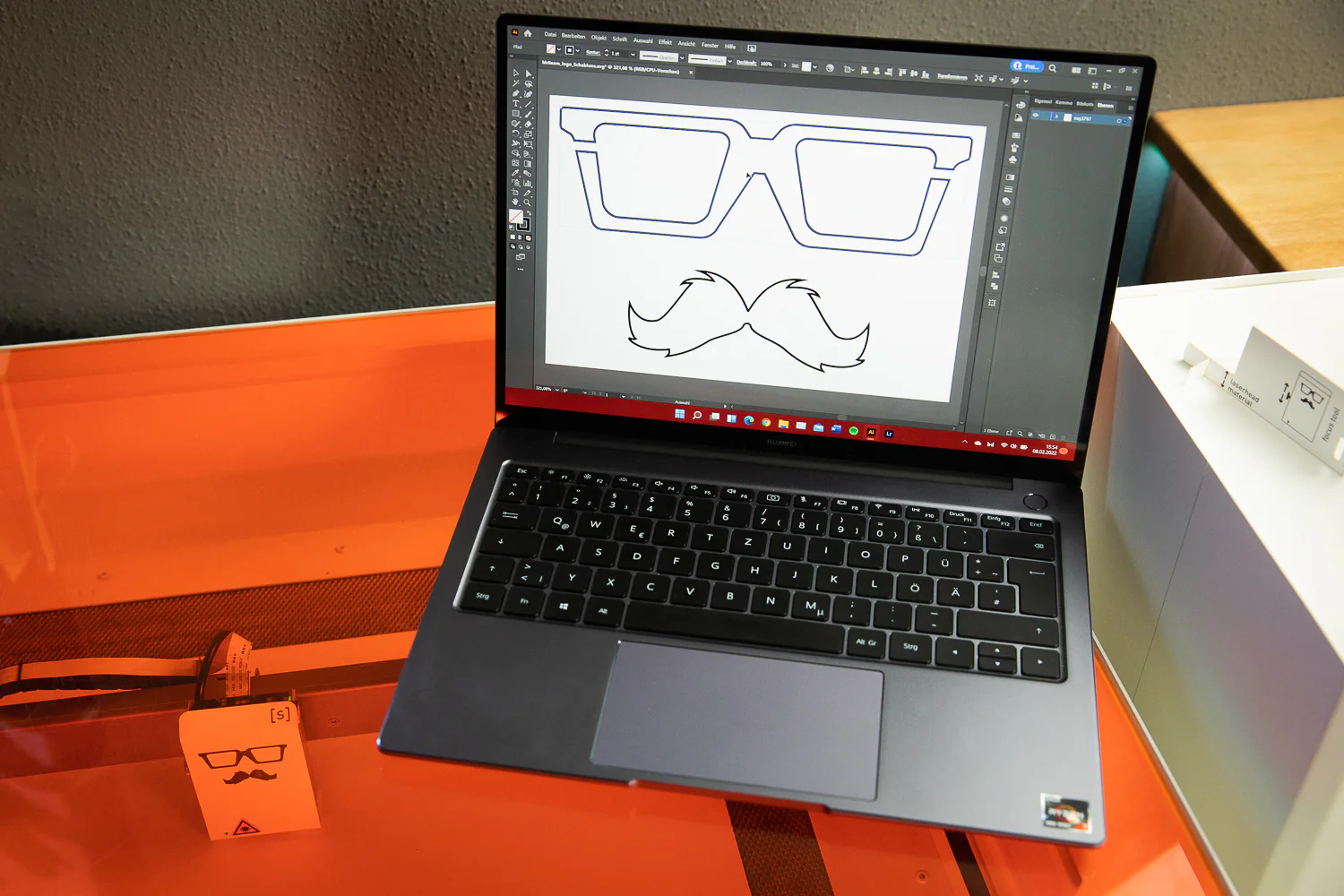 Laptop with a vectorized file in the shape of glasses and mustache on a table